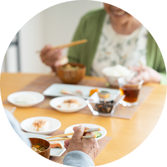 Two people with chopsticks share a meal at a dining table.