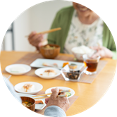 Two people with chopsticks share a meal at a dining table. Two people with chopsticks share a meal at a dining table.
